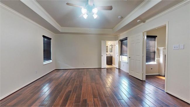 Luxurious primary bedroom featuring an elegant tray ceiling and refined crown molding. | Image 22