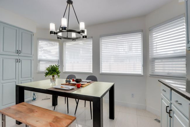 Dining space with a chandelier and light tile patterned floors | Image 9
