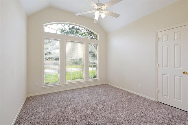 Carpeted spare room featuring lofted ceiling, ceiling fan, and baseboards | Image 8