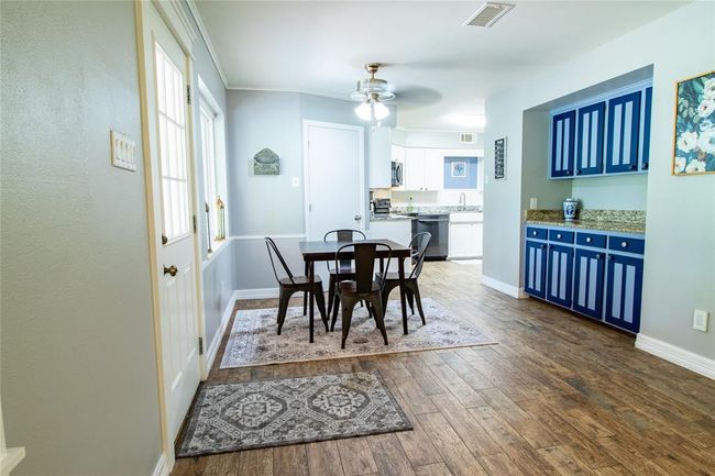 View from the den toward breakfast are and kitchen. Access to the covered back porch is via the door to the left. | Image 37
