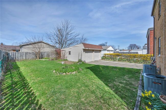 View of yard with an outbuilding, fence, a garage, and central air condition unit | Image 6