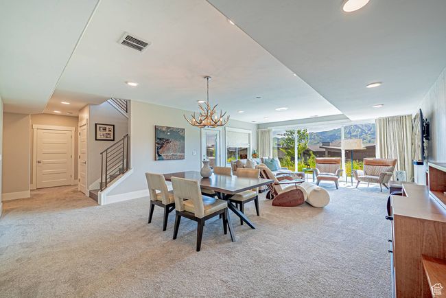 Dining area featuring light carpet, stairs, a chandelier, recessed lighting, and baseboards | Image 18