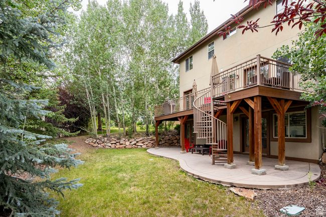 Rear view of house featuring stairs, a patio, stucco siding, and a deck | Image 33