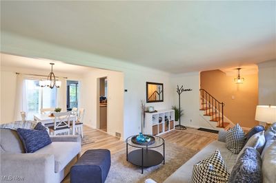 Living room with a notable chandelier and hardwood / wood-style flooring | Image 3