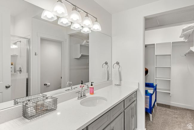 Full bath with a walk in closet, baseboards, vanity, and a shower stall | Image 14