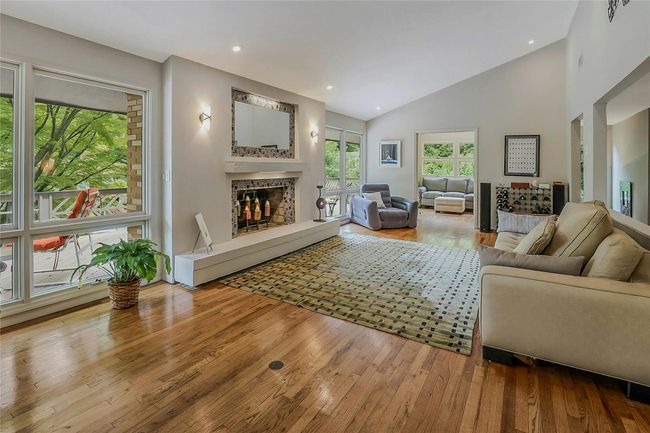 Living area featuring a fireplace, wood-type flooring, vaulted ceiling, and recessed lighting | Image 9