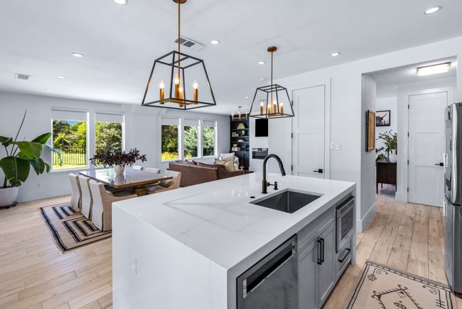 Kitchen featuring stainless steel appliances, waterfall island, chandeliers, Microwave in island. | Image 17