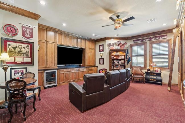 The Media/Libraryfeatures custom-built-in stained cabinets, with upper and lower cabinets to surround the television. Beverage fridge and A/V closet. | Image 14