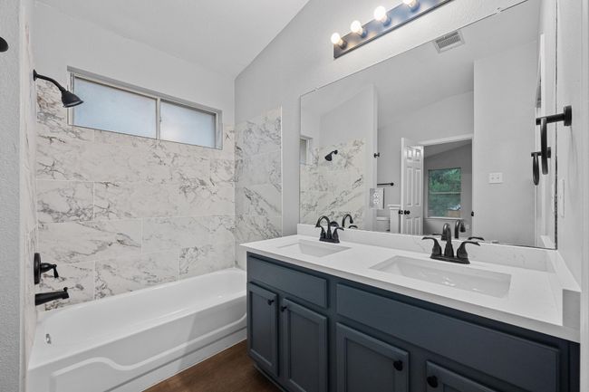 Full bathroom with new double vanity, natural light, shower combination, and vaulted ceiling | Image 14