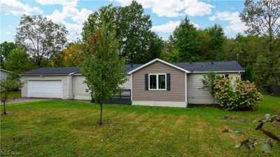 View of front of home with a garage and a front lawn | Image 1