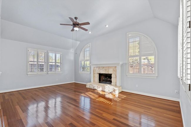 The bright open family room features a cozy fireplace for chilly evenings. | Image 4