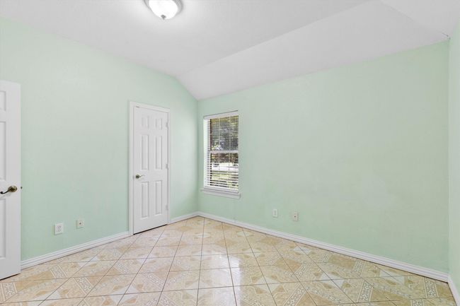 Unfurnished room with light tile patterned floors, lofted ceiling, and baseboards | Image 5