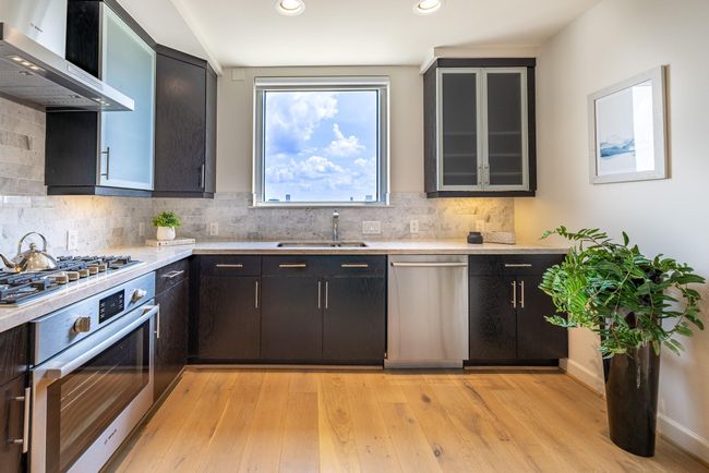 Indulge in a spacious kitchen featuring sleek stainless steel appliances. | Image 8