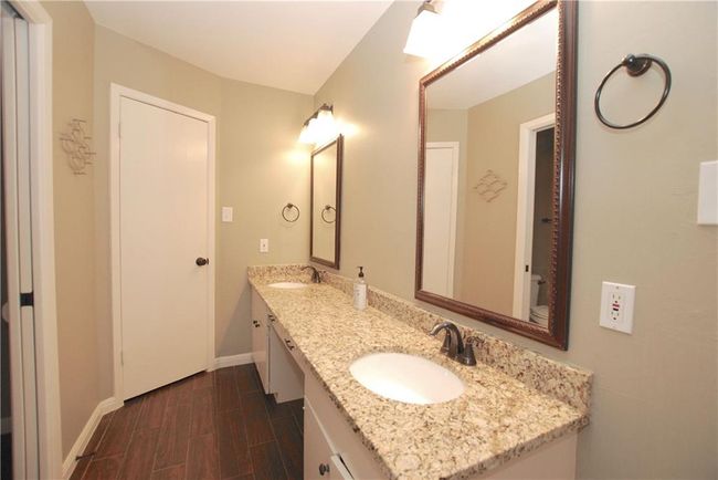 Primary Bathroom with shower, dual vanity sink vanity and wood-like tile floors | Image 13