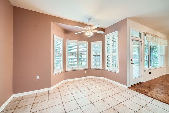Empty room with ceiling fan, baseboards, and light tile patterned floors | Image 14