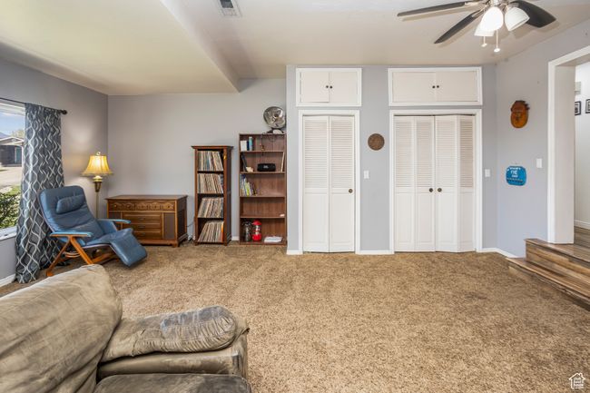 Living area with visible vents, ceiling fan, carpet, and baseboards | Image 16