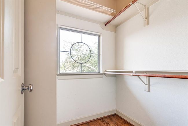Walk in closet for second bedroom. Sturdy shelving and additional natural light from this nautical looking window. | Image 36