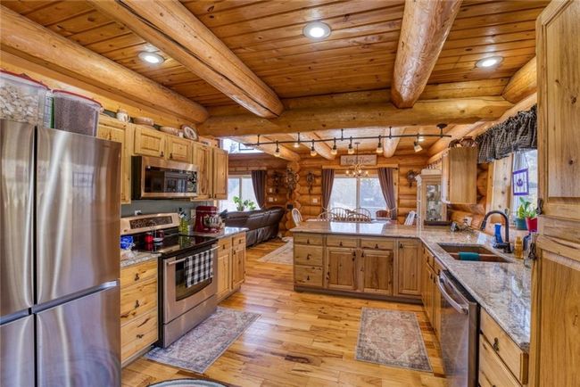 Kitchen featuring beam ceiling, appliances with stainless steel finishes, light wood-style floors, and a sink | Image 15