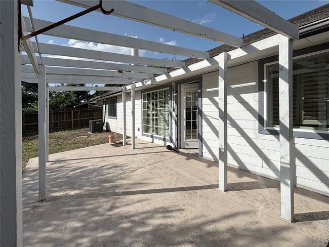 Step outside to a lovely patio area enhanced with a wooden frame, ready for your choice of climbing plants or artificial covering to create your own private retreat. | Image 19