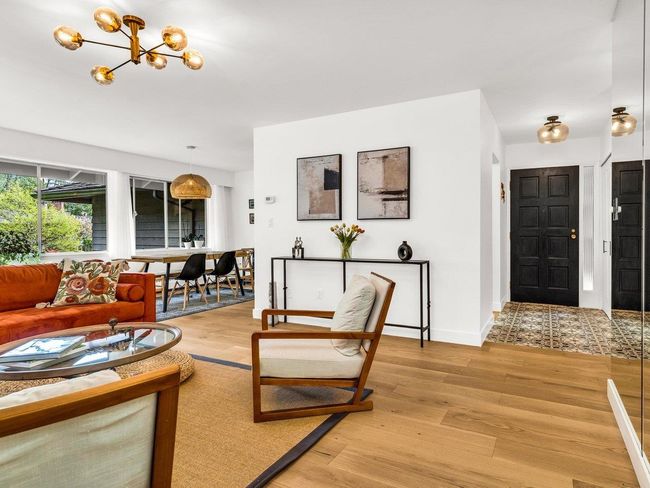 Living room with light wood-type flooring, a chandelier, and baseboards | Image 13