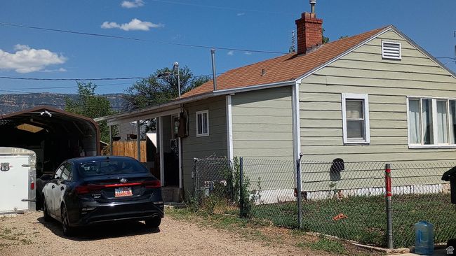 View of side of property featuring a carport and driveway. | Image 57