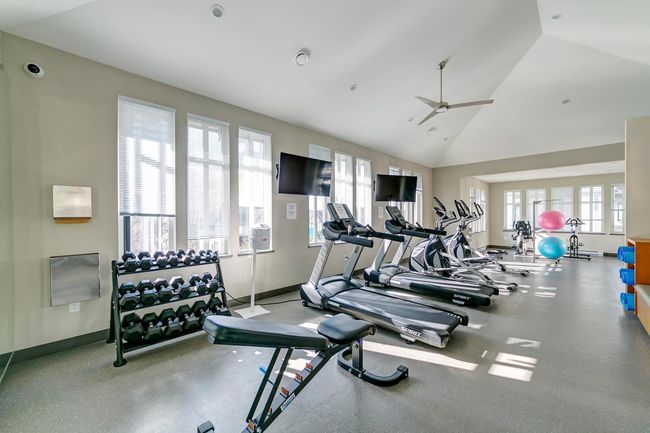 Exercise room featuring healthy amount of natural light, vaulted ceiling, and ceiling fan | Image 39