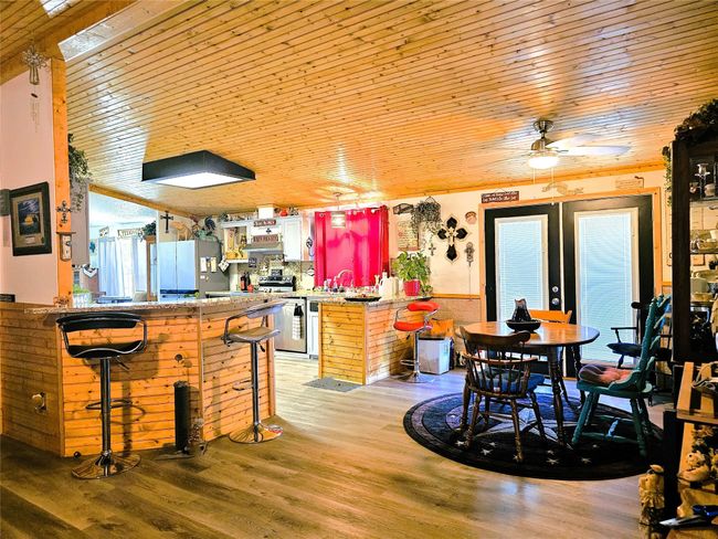 Kitchen with freestanding refrigerator, wood ceiling, a peninsula, a breakfast bar, and a ceiling fan | Image 4