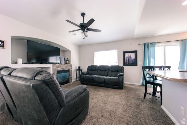 Living area with carpet, ceiling fan, recessed space for TV and gaming, and plenty of natural light. | Image 7