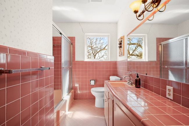 Bathroom with wainscoting, toilet, enclosed tub / shower combo, tile patterned floors, and vanity | Image 20