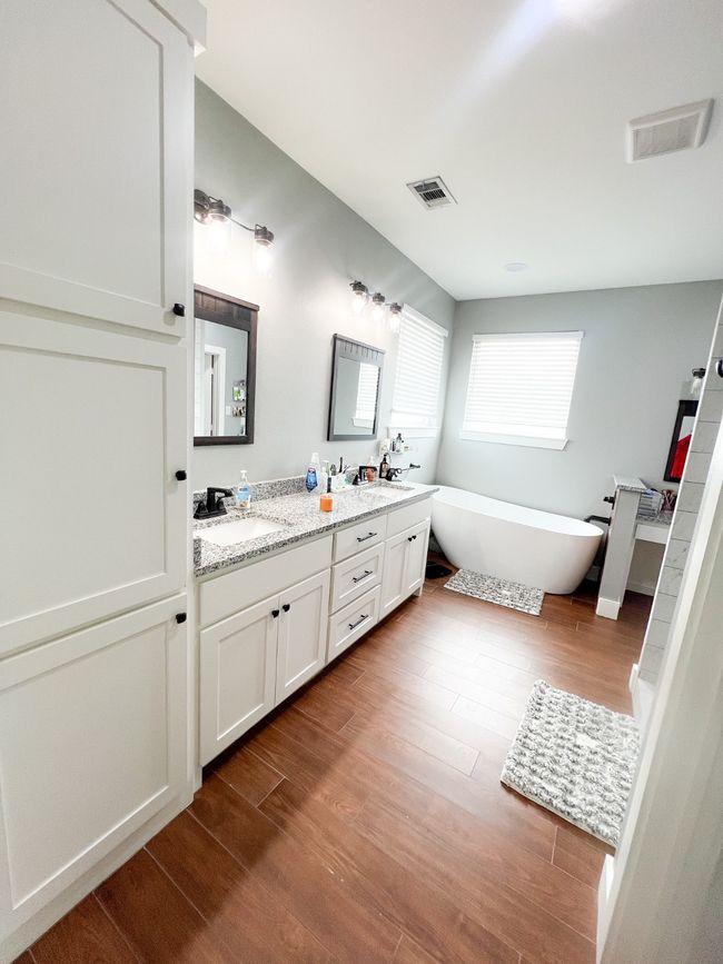Bathroom with vanity, wood-type flooring, and a tub | Image 10