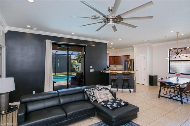 Living area with recessed lighting, ornamental molding, ceiling fan with notable chandelier, and light tile patterned floors | Image 25