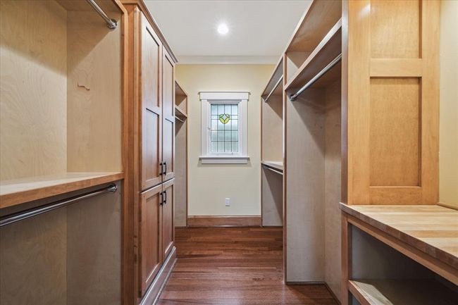 THE PRIMARY SUITE FEATURES A CUSTOM WALK-IN CLOSET DESIGNED FOR ULTIMATE ORGANIZATION OUTFITTED WITH BUILT-IN CABINETS, AMPLE SHELVING AND MULTIPLE HANGING RODS. | Image 31