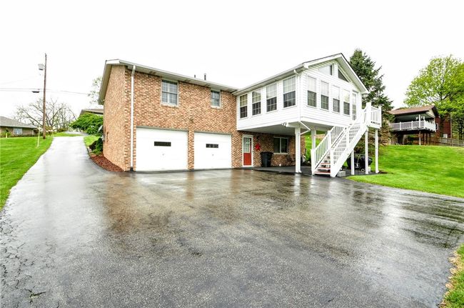 Here you see the spacious 2 car garage along with the carport and the stairs to the sunroom. You have room for a lot of vehicles in this driveway! | Image 8