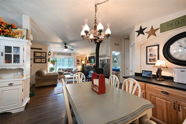 Dining area featuring a chandelier, dark wood finished floors, and a ceiling fan | Image 27