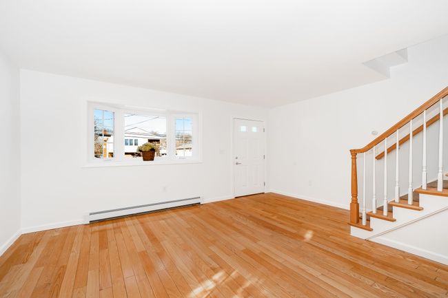 Foyer entrance with baseboards, stairs, baseboard heating, and hardwood / wood-style flooring | Image 10