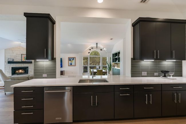 Kitchen featuring lofted ceiling, a sink, open floor plan, light countertops, and backsplash | Image 9