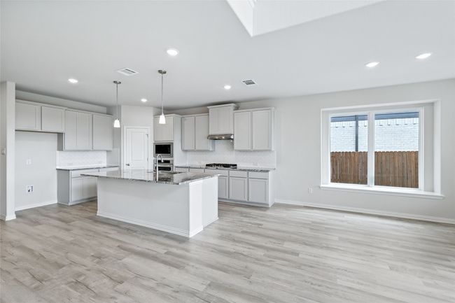 Kitchen with appliances with stainless steel finishes, decorative backsplash, light wood-type flooring, and recessed lighting | Image 11