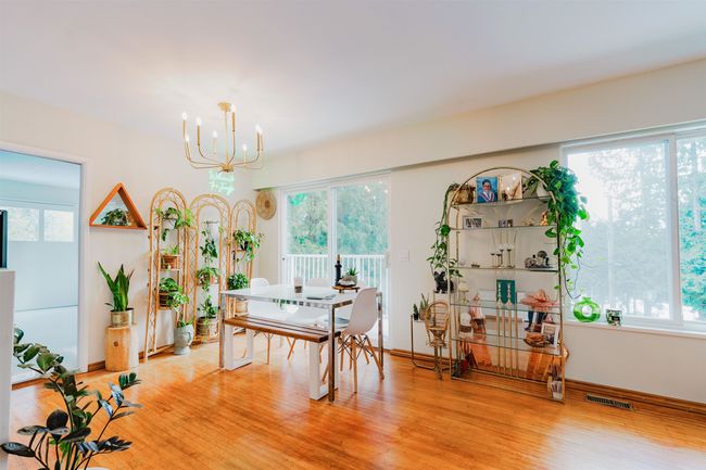 Dining area featuring baseboards, a notable chandelier, light wood finished floors, and visible vents | Image 7