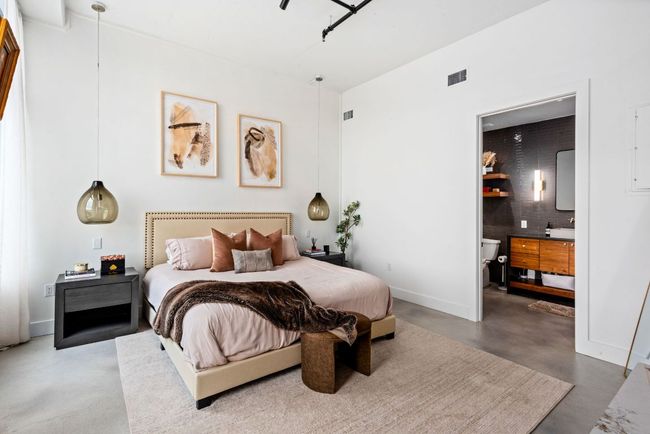 Bedroom featuring finished concrete flooring and ensuite bath | Image 22