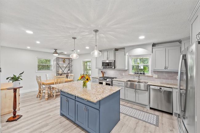 Modern kitchen equipped with stainless steel appliances, granite countertops, and ample cabinetry. | Image 6
