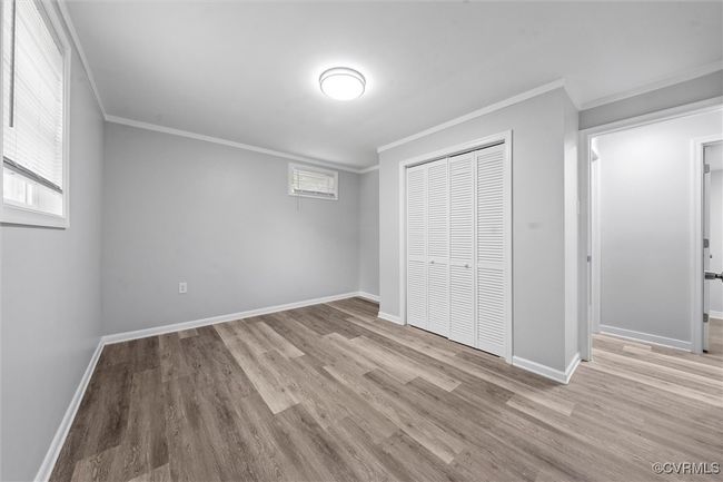 Unfurnished bedroom featuring ornamental molding, a closet, wood finished floors, and baseboards | Image 30
