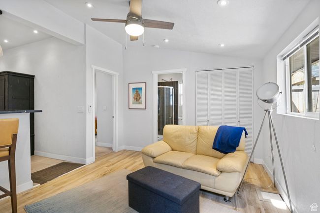 Living room with lofted ceiling, baseboards, recessed lighting, light wood-style flooring, and ceiling fan | Image 5