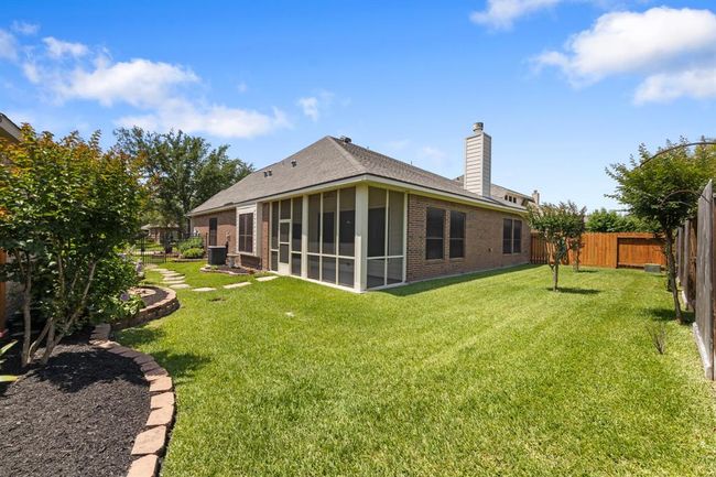 The beautifully landscaped backyard offers plenty of open space, perfect for kids and pets to play. Lush greenery and thoughtful design create a serene outdoor to relax or appreciate beautiful summer afternoons. | Image 39