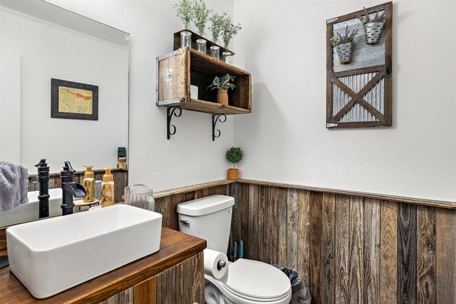 Bathroom featuring wainscoting, toilet, vanity, and wood walls | Image 27