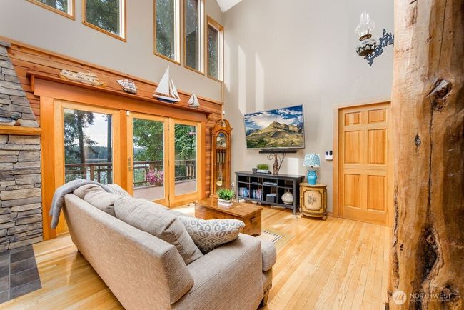 Living room with water view, vaulted ceiling and beautiful log pillars. Walks out onto wrap-around trex deck. | Image 6