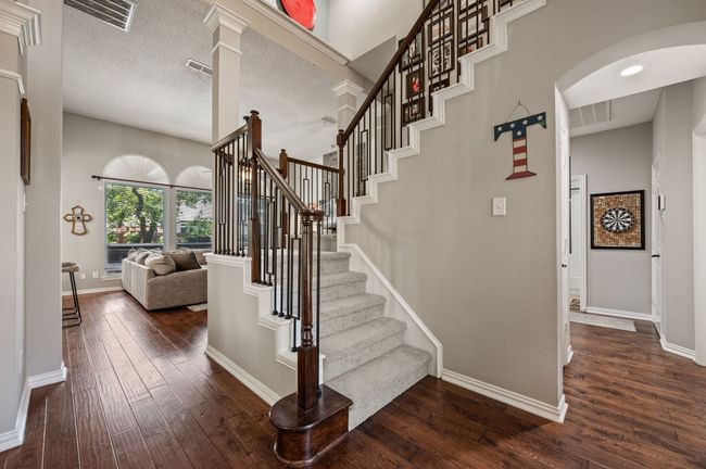 Stairs with hardwood / wood-style floors, a textured ceiling, and arched walkways | Image 20