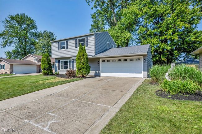 View of front of property with an attached garage, a front lawn, and concrete driveway | Image 5