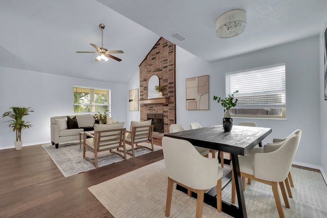 Dining room featuring a fireplace, a ceiling fan, wood finished floors, and high vaulted ceiling | Image 15