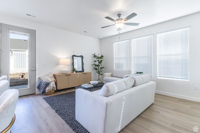 Living room with light wood finished floors and ceiling fan | Image 14