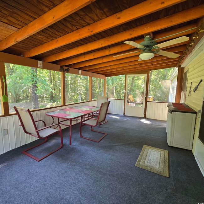 Sunroom / solarium with outdoor dining space, ceiling fan, and beam ceiling | Image 33